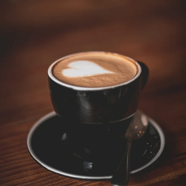 Black coffee cup on a warm wooden café table
